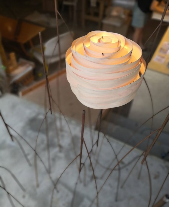 Stojací lampa připomínající růži ze dřeva na kovovém podstavci, možnost výběru ze dvou velikostí, světlo Vayehi Roza.