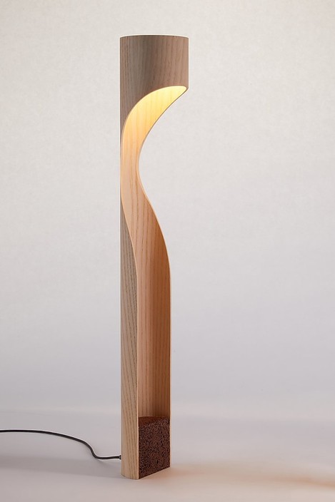 Stojací lampa od Studio Vayehi, Monk z ohýbaného dřeva s LED světlem, možnost výběru ze tří druhů dýhy – dubu, jasanu a ořechu – a zvolení barvy podstavce – bílé, okrové, šedé, tmavě hnědé, kovové.  (Dýha: jasan)