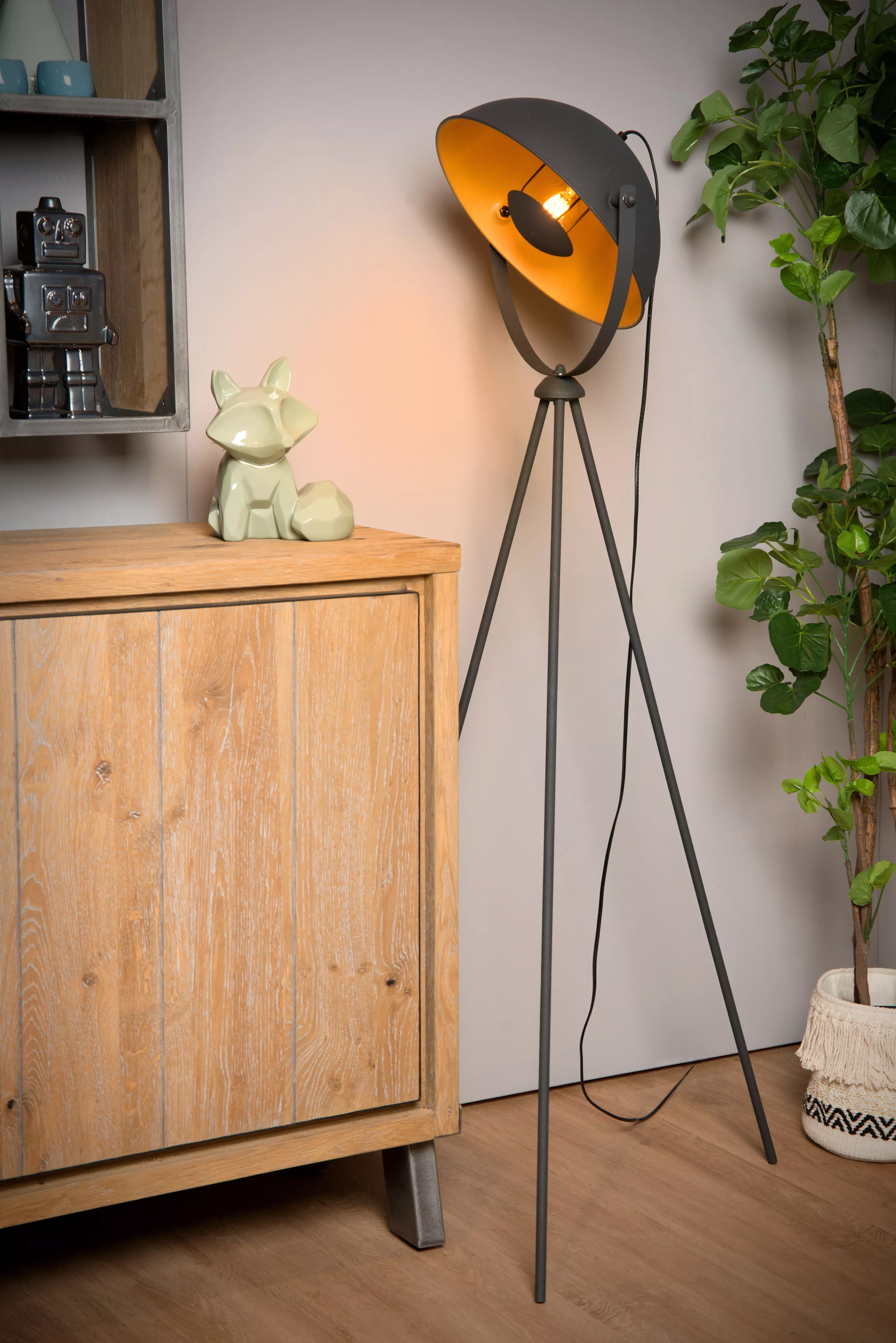 Černá stojací lampa Alvaro s mosaznými detaily na třech nohách navodí v obývacím pokoji nebo čtecím koutku příjemnou atmosféru.