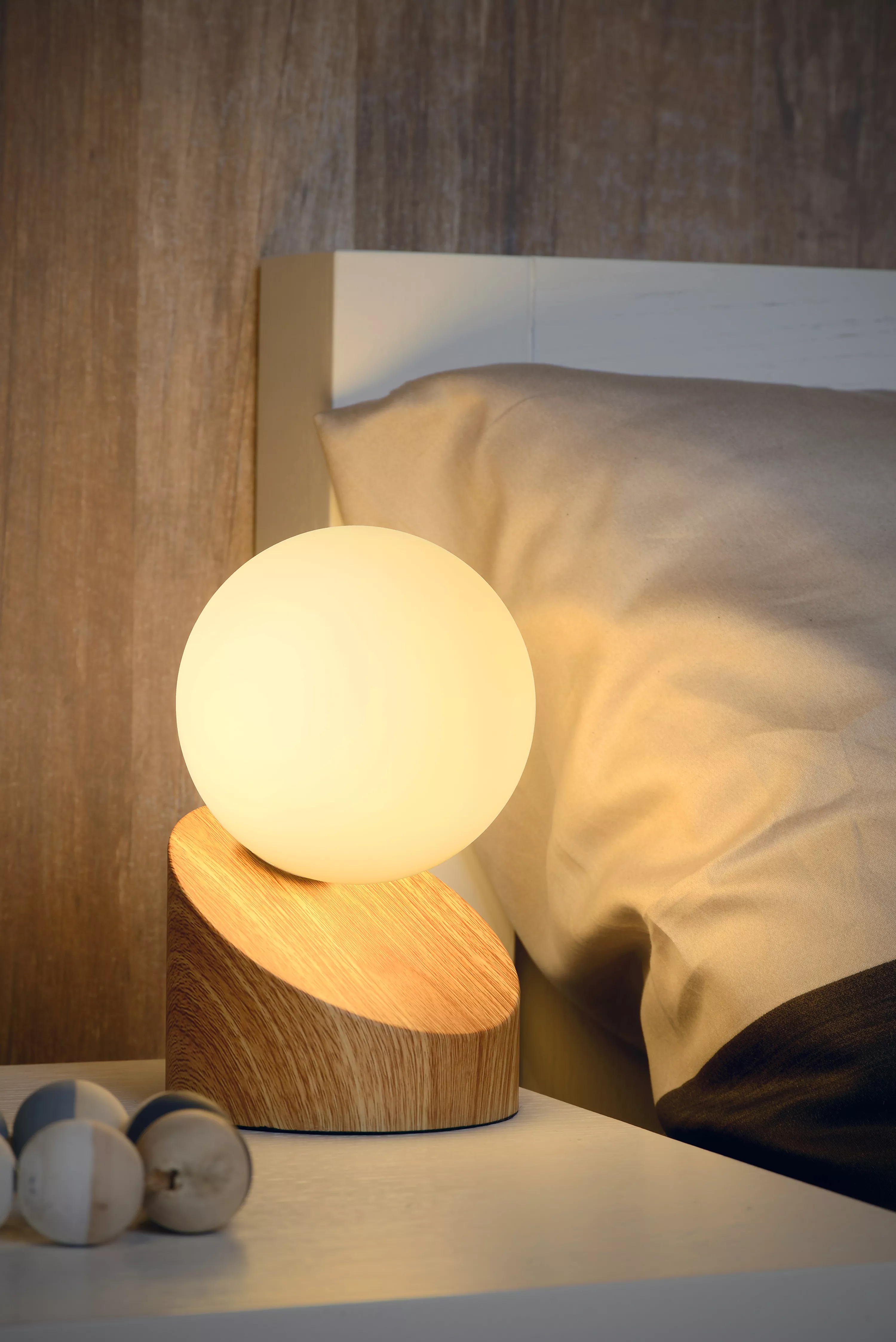 Asymetrická stolní lampička Len s kovovou základnou a opálovou skleněnou kopulí poskytuje příjemně rozptýlené světlo.