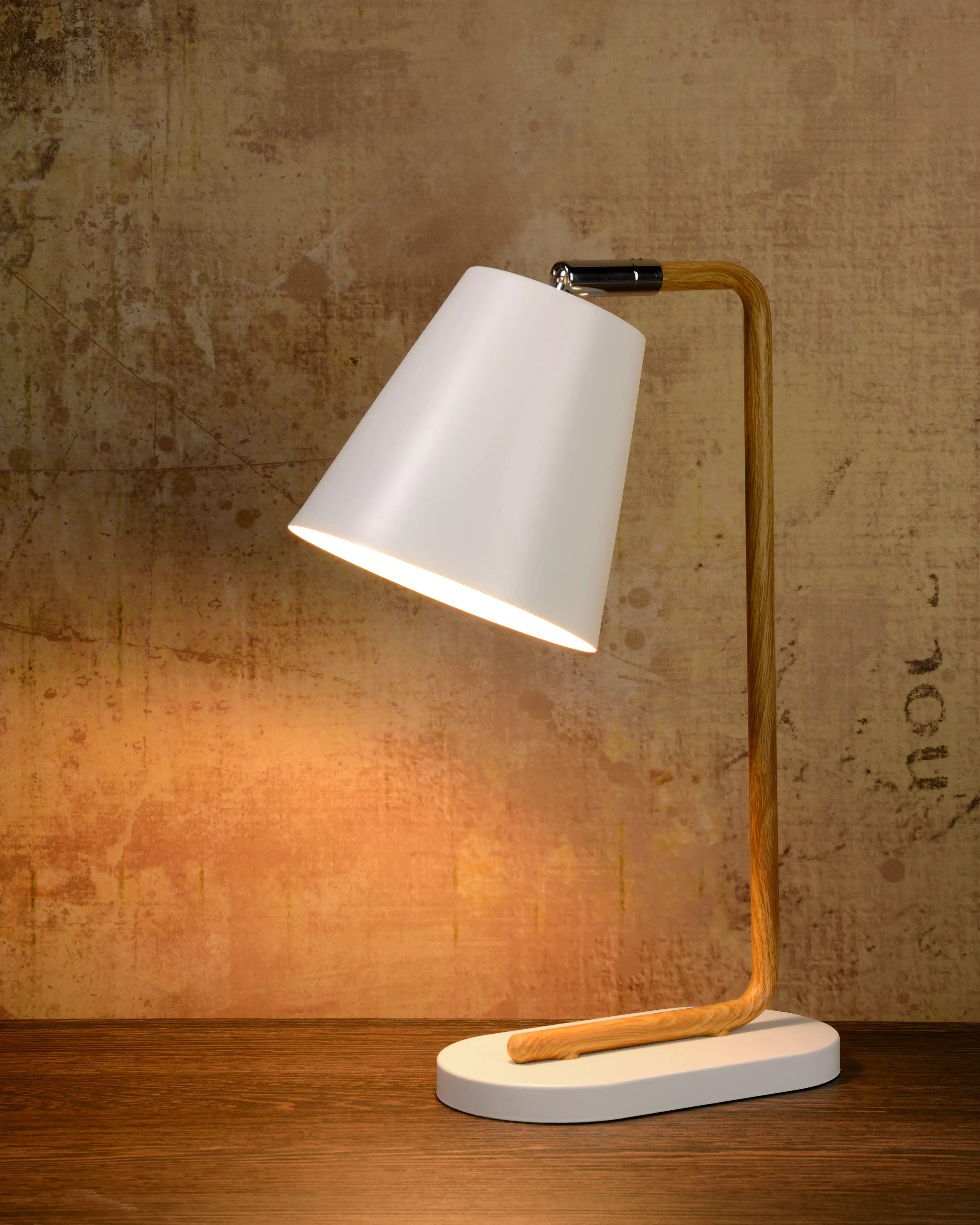 Stolní lampička Cona v bílém provedení s kovovou tyčí v motivu dřeva a s otočným kloubem pro snadné směrování stínítka.