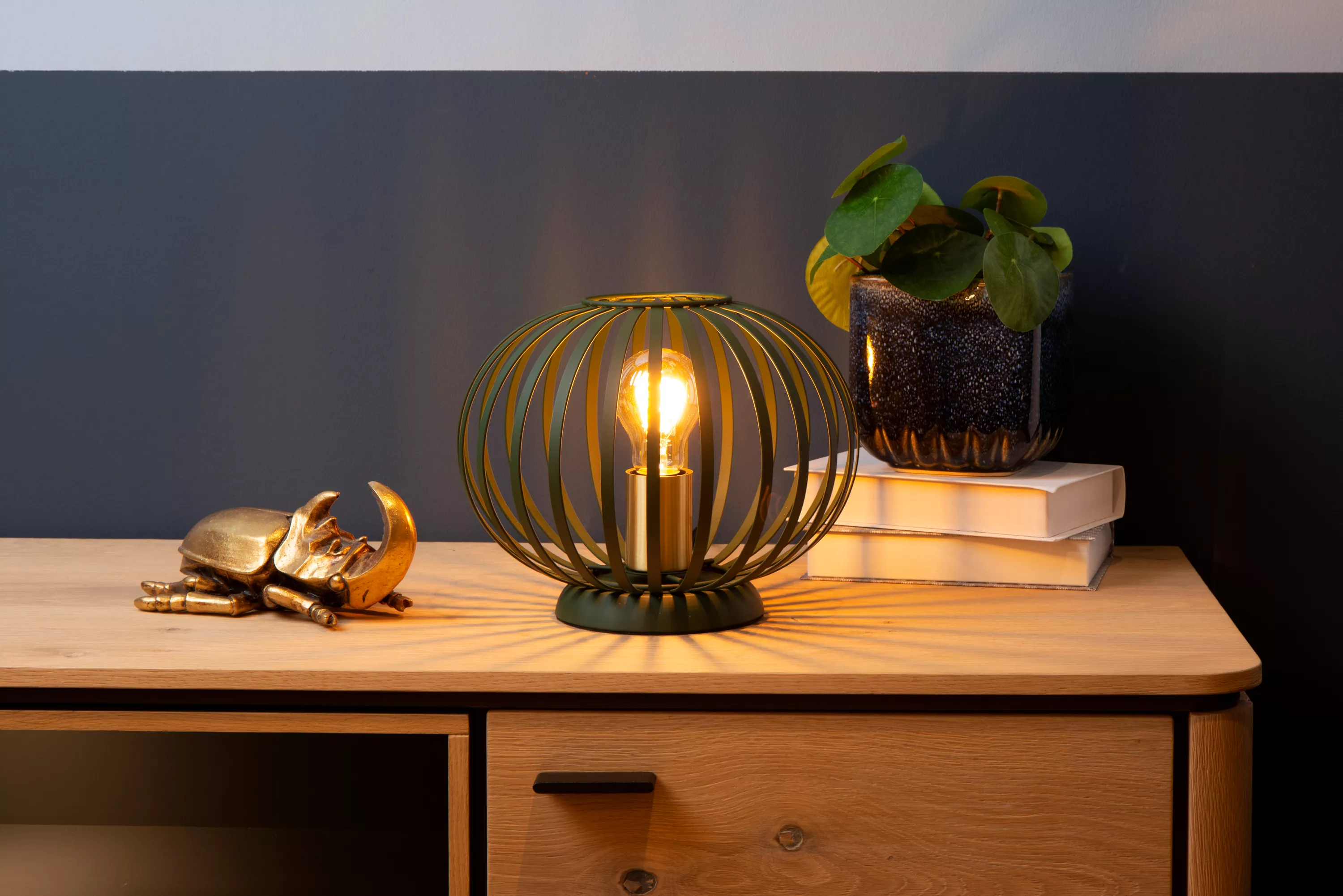 Moderní stolní lampička Manuela tvořená dráty v zeleném provedení se hodí do moderního interiéru i domu ve venkovském stylu.