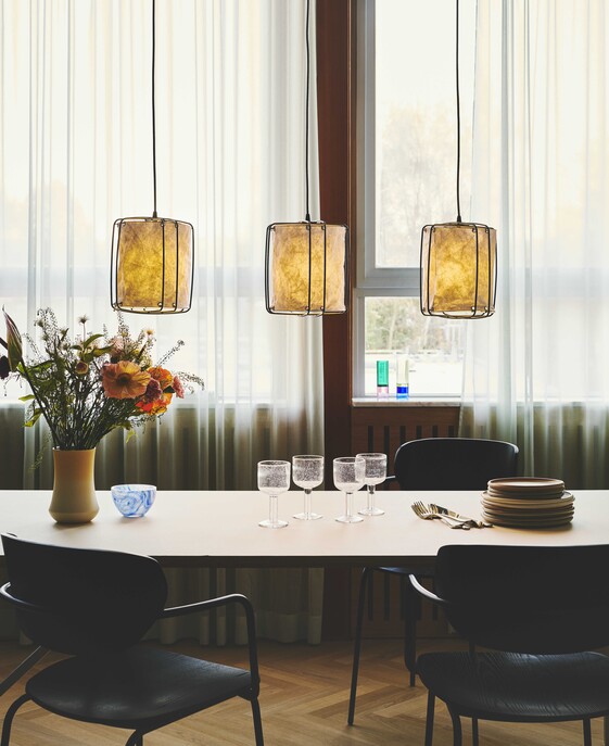Závěsné svítidlo Cardine inspirované japonskou filozofií a severským minimalismem. 3 bílá zvlněná stínítka zavěšená na černých kovových drátech poskytují rozptýlené světlo ideální nad jídelní stůl. 