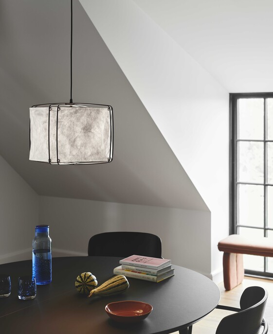 Závěsné svítidlo Cardine 30 inspirované japonskou filozofií a severským minimalismem. Bílé zvlněné stínítko zavěšené na černých kovových drátech poskytuje rozptýlené světlo ideální nad jídelní stůl. 