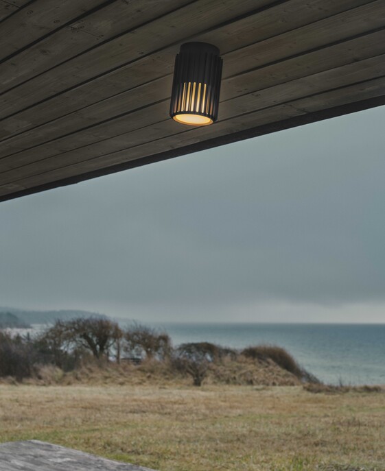 Venkovní stropní světlo Aludra Seaside od Nordluxu v moderním minimalistickém designu. Díky specifickému tvaru vytváří v okolí hru světla a stínu. Vyrobené z odolného materiálu, dostupné ve třech barevných provedeních – černá, antracit a metalická hnědá.