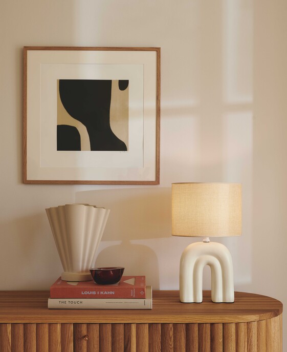 Stolní lampička Haze kombinuje keramiku a lněné stínítko, které dodává interiéru měkké světlo. Dostupné v béžové barvě.