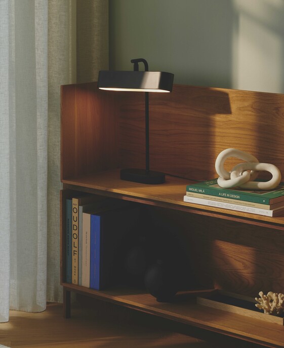 Stolní lampička Merlin v minimalistickém designu s funkční nastavitelnou hlavou, dostupná v černé barvě.