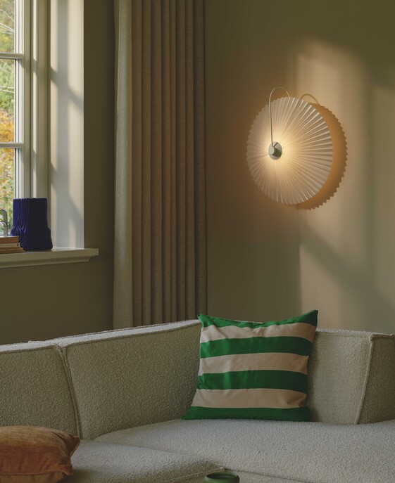 Nástěnné svítidlo Nadia se skládaným stínítkem, které poskytuje rozptýlené světlo, je doplněno o kovový rám. Vhodné do ložnice nebo obývacího pokoje.