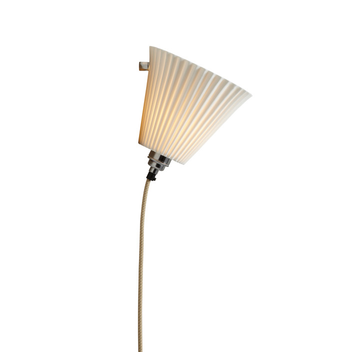 Nástěnná lampička Portable Pleat od Original BTC se skládaným porcelánovým stínítkem v bílé barvě, drobná základna, dlouhý kabel zapojitelný do zásuvky, vypínač na kabelu, ve dvou velikostech. (Průměr: Ø19cm)